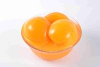 Здоровые, который слезли законсервированные желтые куски персика в сырье светлого сиропа свежем